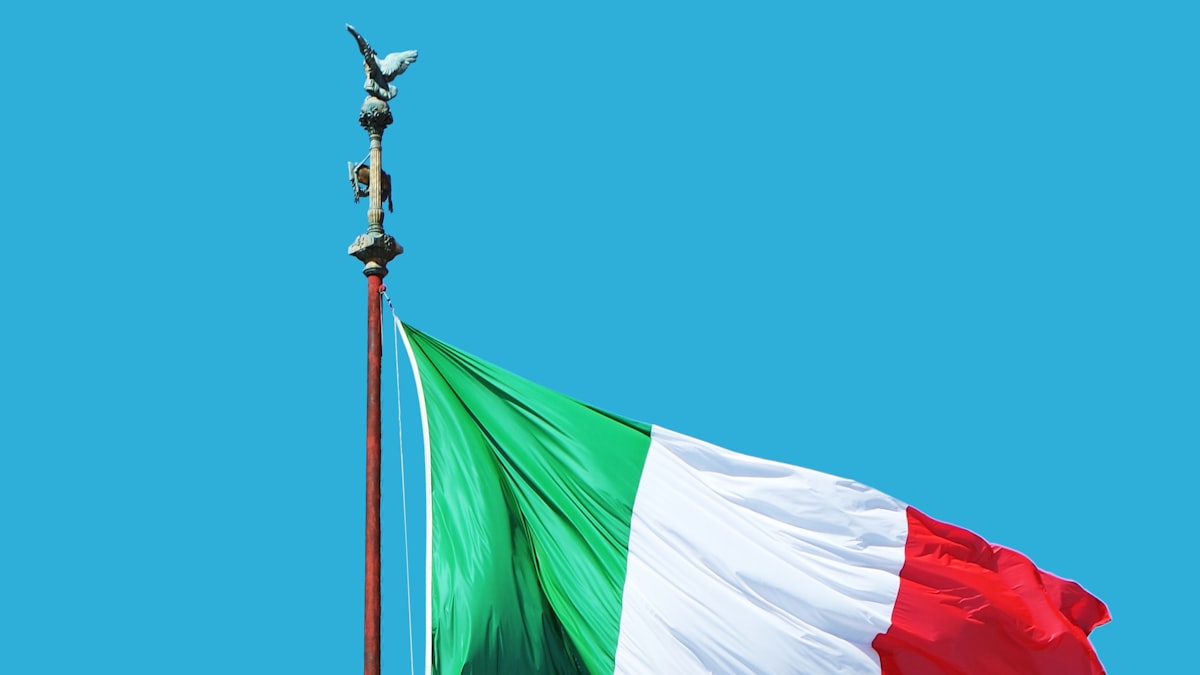The flag of Italy waving against a blue sky